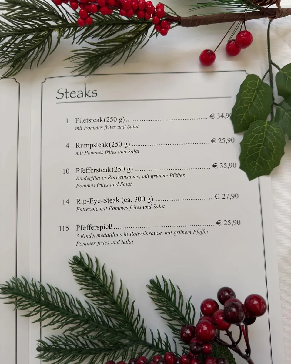 Klassische Speisekarte von Haus Wessels, dekoriert mit Tannenzweigen und roten Beeren